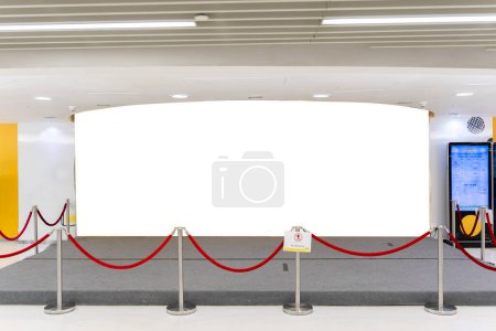 Mockup large horizontal blank billboard at front of restaurant with  and warning sign do not entry near corridor of shopping mall, empty space for advertisement or promotion with spotlight on ceiling