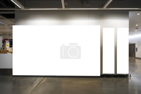 Mockup diferentes tamaños de tres carteles en blanco con iluminación cerca de la pared y el pasillo en el edificio, espacio vacío para insertar su anuncio 