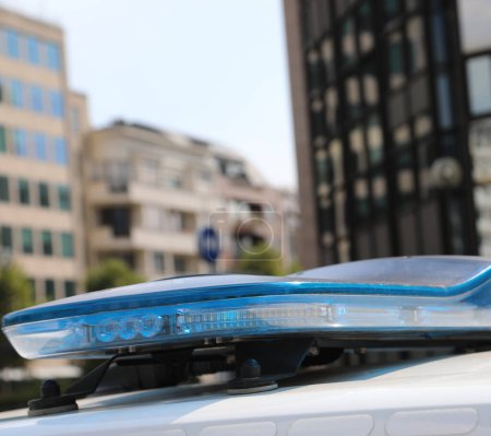 Téléchargez les photos : Feux clignotants bleus de la voiture de police tout en patrouillant dans la ville - en image libre de droit