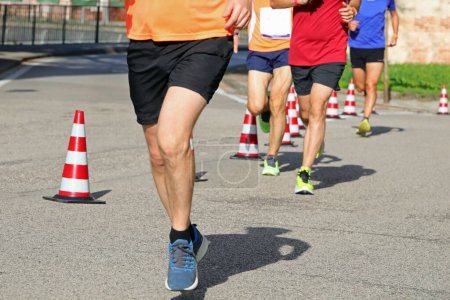 Foto de Atleta con largas piernas musculares durante la carrera a pie en la ciudad - Imagen libre de derechos