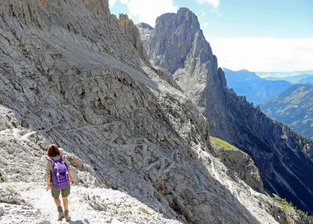 Foto de Joven excursionista caminando por el sendero en las montañas italianas en verano - Imagen libre de derechos