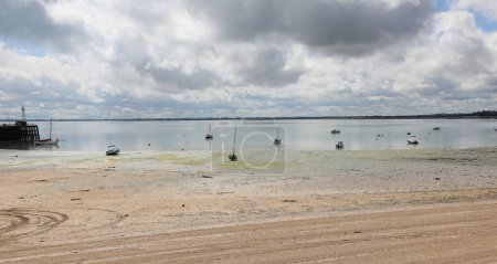 Photo for Beached boats stranded in quicksand by the sea at low tide - Royalty Free Image