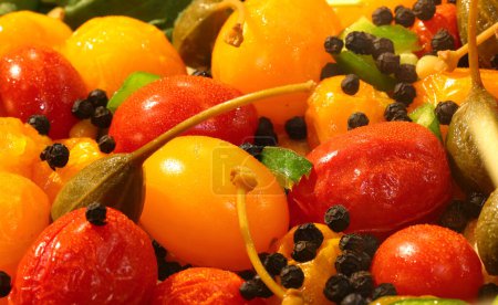 Téléchargez les photos : Fond avec des produits méditerranéens frais tels que tomates cerises jaunes et rouges et câpres - en image libre de droit