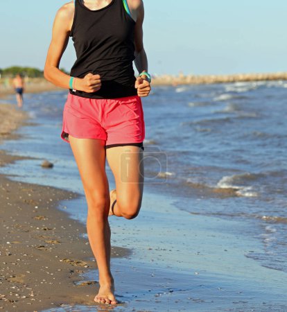 Photo for Young girl jogging running on the seashore in summer - Royalty Free Image
