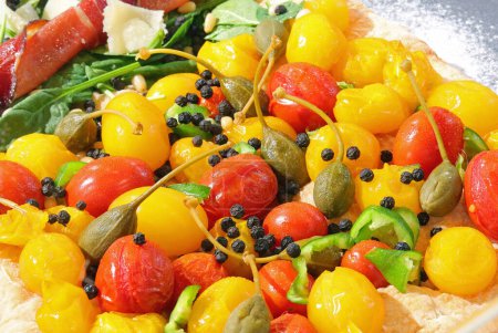 Téléchargez les photos : Fond avec des produits méditerranéens frais tels que tomates cerises jaunes et rouges et câpres - en image libre de droit