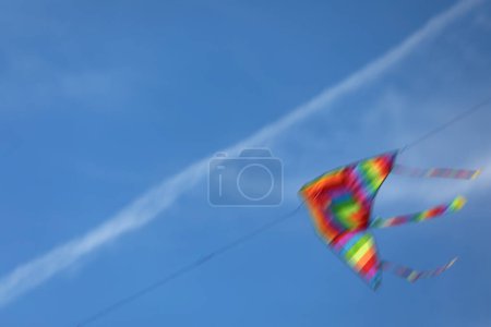 Foto de Desenfoque intencional de una cometa con los colores del arco iris volando en el cielo - Imagen libre de derechos