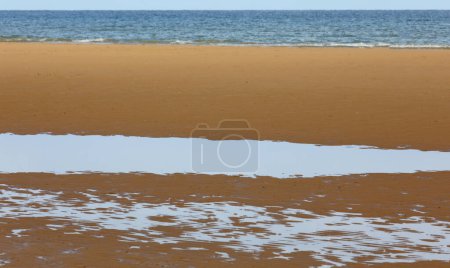 Photo for Golden sand of the beach by the sea and puddles after high tide - Royalty Free Image
