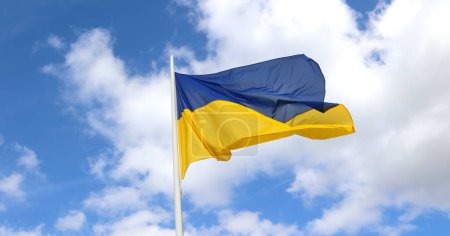 Photo for Yellow and blue flag of Ukraine and sky with white clouds in background - Royalty Free Image