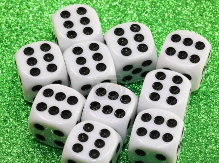 Foto de Gambling dice on green shiny casino table ALL with SIX number - Imagen libre de derechos