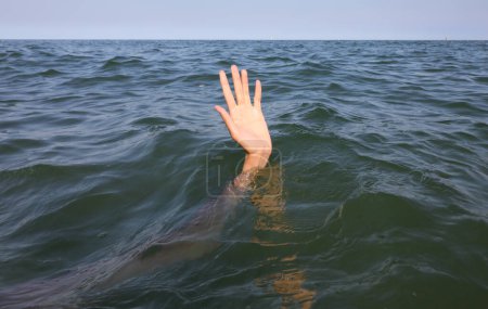 Téléchargez les photos : Human hand of the person about to drown in the middle of the sea after shipwreck - en image libre de droit