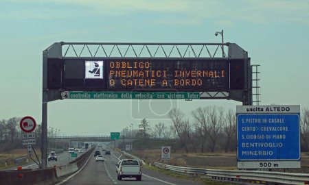 Téléchargez les photos : Autoroute avec texte qui signifie équipement d'hiver obligatoire et contrôle de vitesse en langue italienne - en image libre de droit