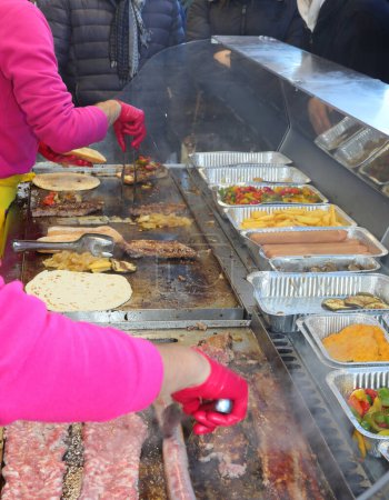 Téléchargez les photos : Cooks that cook street food with meat and vegetables in the hot metal plate in the stall at the fair - en image libre de droit