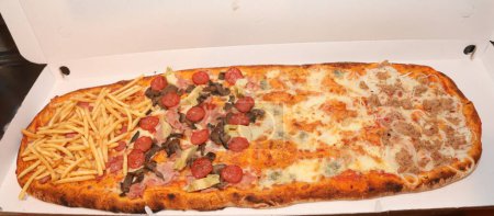 huge long pizza with tomato cheese mozzarella spicy salami mushrooms in takeaway packaging