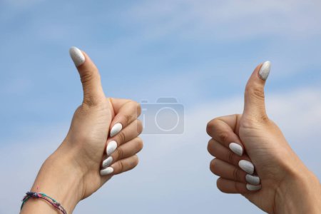 Foto de Dos pulgares hacia arriba de las manos con el esmalte en las uñas de la joven símbolo de OK - Imagen libre de derechos