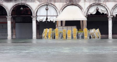 Photo for High tide in Venice Island in Italy chairs and tables of the alfresco cafe without the people - Royalty Free Image