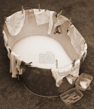 Photo for Washtub with clothespin and clothes with old toned sepia effect without people - Royalty Free Image