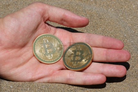 Téléchargez les photos : Deux pièces d'or symbolisant la crypto-monnaie Bitcoin à la main - en image libre de droit