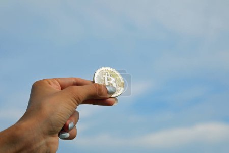 Téléchargez les photos : Jeune fille avec pièce d'or avec majuscule B symbolisant Bitcoin crypto-monnaie - en image libre de droit