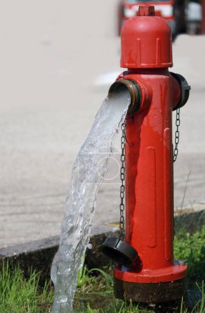 Foto de Hidrante rojo y el agua refrescante que sale - Imagen libre de derechos