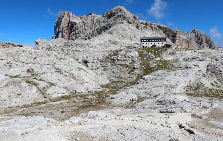 Foto de Meseta pedregosa que parece casi un paisaje lunar en la cordillera de los Dolomitas y un refugio alpino - Imagen libre de derechos
