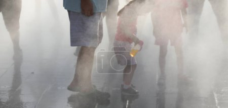 Foto de Agua nebulizada para enfriar las piernas de los transeúntes durante la temporada de verano en la ciudad - Imagen libre de derechos
