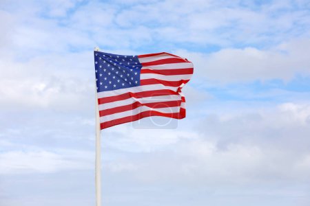 Téléchargez les photos : Couleurs vives du grand drapeau américain agitant dans le vent et le ciel bleu - en image libre de droit