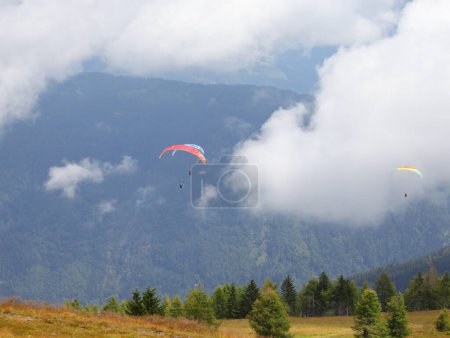 Photo for Some paragliders even have two people flying at the same time in the clouds in the mountains - Royalty Free Image