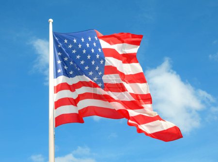 Téléchargez les photos : Couleurs vives du grand drapeau américain agitant le vent et le ciel - en image libre de droit