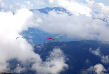 Photo for Paragliding with two people on board for a couple flight and the clouds in the high mountains - Royalty Free Image