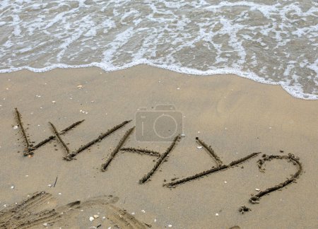 Foto de TEXTO POR QUÉ con el signo de interrogación en mayúsculas escrito en la arena junto al mar ideal como final para presentaciones y preguntas frecuentes - Imagen libre de derechos