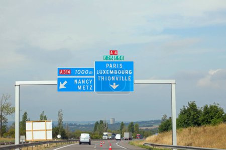 Photo for Large road sign on the road leading to Paris or Luxembourg and some car traffic - Royalty Free Image