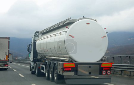 Photo for Large truck for the transport of liquids travels fast on the highway - Royalty Free Image