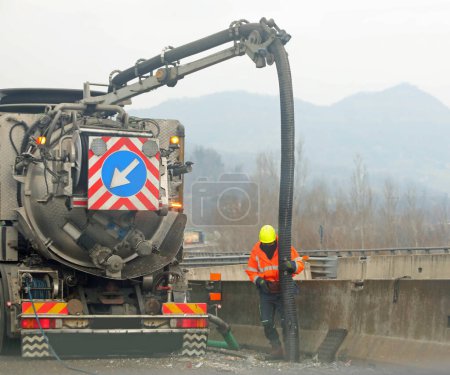 Photo for Large truck with hose for maintenance of motorways and highways and the operator at work - Royalty Free Image