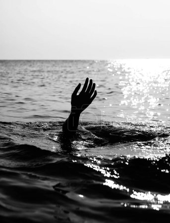 Photo for Hand of the person about to drown in the middle of the ocean in very dramatic black and white - Royalty Free Image
