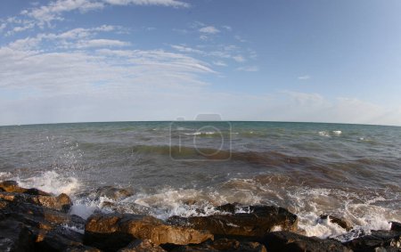Photo for The waves crashing on the rocks and the sea on a sunny day with the blue sky - Royalty Free Image
