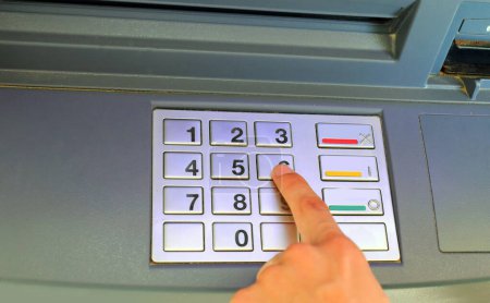 Hand von Jugendlichen tippt geheimen PIN-Code ein, um Zugang zu Bankdienstleistungen eines Geldautomaten zu erhalten