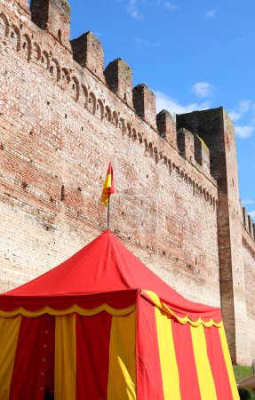Foto de Cittadella, PD, Italia - 24 de septiembre de 2023: Antigua muralla y tienda de campaña de soldados rojos y amarillos - Imagen libre de derechos