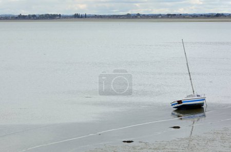 Photo for Stranded boat on sand without water during low tide in Northern France - Royalty Free Image