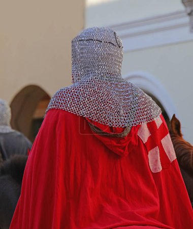 Téléchargez les photos : Chevalier médiéval avec des vêtements anciens et une protection en métal sur la tête appelé chaîne mail pendant le défilé de reconstitution historique - en image libre de droit