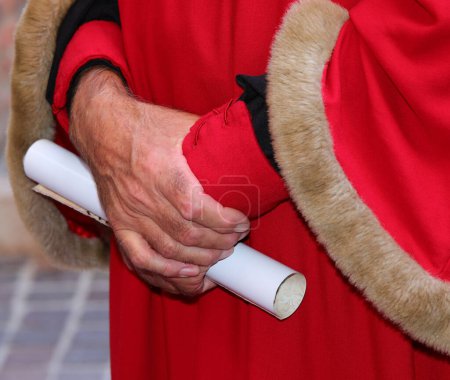 Téléchargez les photos : Élégante robe rouge avec des inserts en fourrure douce et le parchemin à la main - en image libre de droit