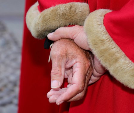 Téléchargez les photos : Robe rouge élégante royale avec inserts en fourrure douce et grandes mains de l'homme - en image libre de droit