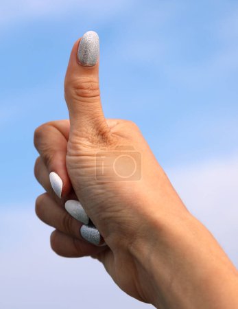 Téléchargez les photos : Main faisant pouce signe Signification succès avec fond de ciel - en image libre de droit
