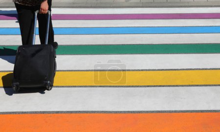 coloridas rayas coloridas de un cruce peatonal y viajero con carro de mano en la calle de la ciudad