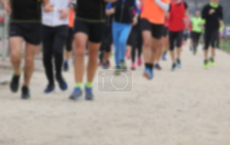Foto de Intencionalmente fuera de foco piernas de corredores corriendo en grupo durante la carrera a pie en la ciudad - Imagen libre de derechos