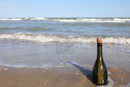 Photo for Beached bottle with a secret message inside or a pirate treasure map on the seashore - Royalty Free Image