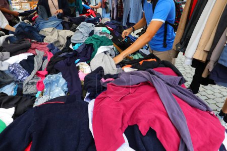 person looking for used clothes in the flea and used clothing market