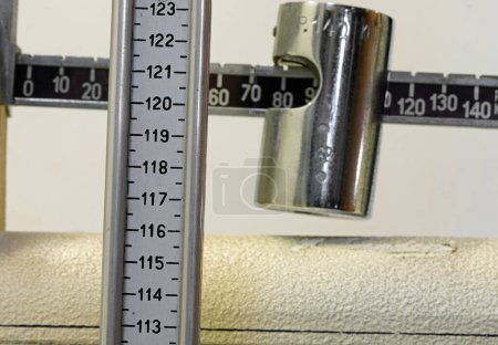 Gewichts- und Größenangaben der Patienten während der medizinischen Untersuchung auf einer antiken Badwaage aus Metall