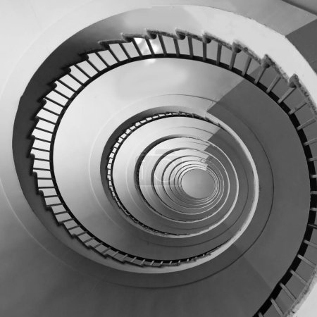 Photo for Spiral staircase seen in perspective with the steps going towards infinity in black and white - Royalty Free Image