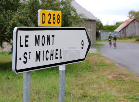 Photo for Road sign with arrow and directions to the Mont Saint Michel Abbey in Northern France - Royalty Free Image
