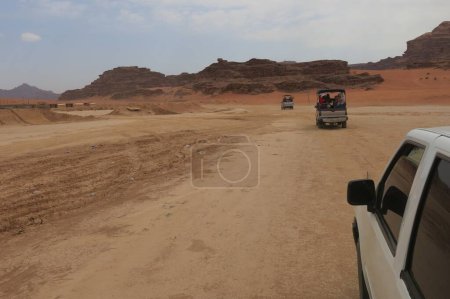 Photo for 4x4 OffRoad Vans Carrying Passengers and Equipment Across Desert Terrain - Royalty Free Image